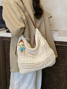 Large cream hand-woven crochet beach bag with brown leather strap and doll charm