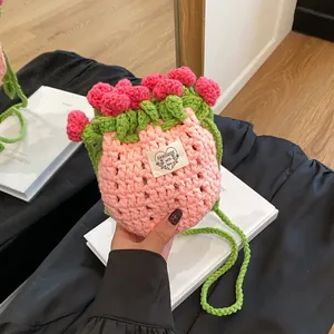 Détail de la pochette en crochet faite main avec des roses et une bandoulière verte