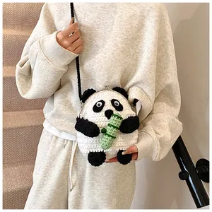 Detail of handmade panda crochet crossbody bag with metal clasp and green bamboo accent