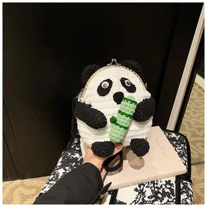 Macro shot of handmade crochet panda bag with metal clasp and green bamboo detail