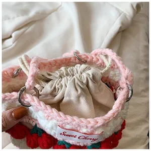 Detailed macro view of the handmade cherry crochet bag with inner canvas drawstring bag