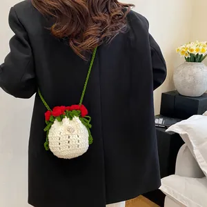 Détail du sac seau rose fait main au crochet avec bandoulière porté par un mannequin