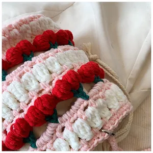 Close-up of handmade crochet bag showing pink wave patterns and 3D cherry details