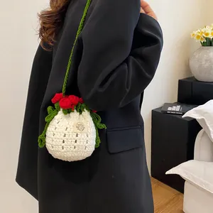 Détail du sac seau rose fait main au crochet avec bandoulière verte et fleurs