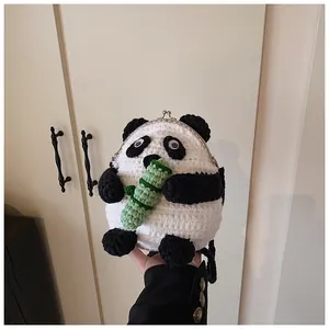 Detail of handmade crochet panda bag with metal clasp and green bamboo accent