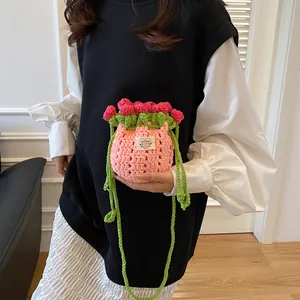 Détail du sac seau rose fait main au crochet avec tulipes et bandoulière tressée