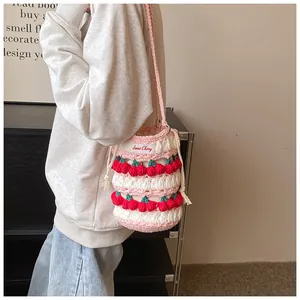 Detail of handmade crochet cherry bucket bag with Sweet Cherry label and woven strap