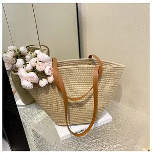 Detail of a woven straw tote bag with brown leather handles and spacious interior storage