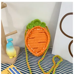 Detail of handmade crochet carrot bag featuring bright orange weave and green leaf accents
