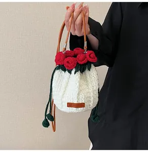 Detail of hand-knitted crochet bucket bag featuring 3D red roses and a Hand Made label