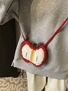 Handmade crochet apple-shaped crossbody bag for kids with red yarn and green leaf detail