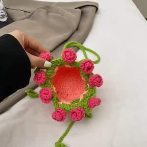 Détail du mini sac seau au crochet avec roses roses 3D et bandoulière verte tissée