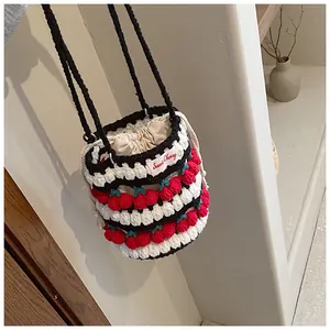 Macro shot of handmade crochet cherry bucket bag showing intricate knit texture and pattern