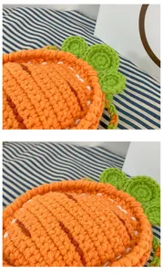 Close-up of handmade crochet carrot bag showing dense orange yarn texture and green leaf detail