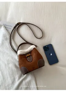 Détail du sac seau en daim marron avec bordure en fausse fourrure et fermoir doré