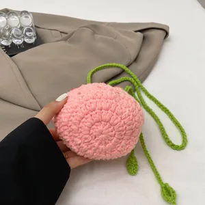 Détail macro du sac seau pêche au crochet fait main avec fil rose et feuilles vertes
