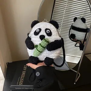 Detail of handmade crochet panda bag with metal clasp and green bamboo accent
