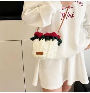 Detail of hand-crocheted white bucket bag with red roses and Hand Made leather tag