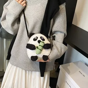 Detail showing the panda crochet bag worn by a model with metal clasp and bamboo accent