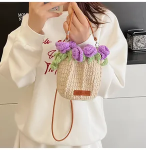 Detail of handmade knit bucket bag with 3D purple roses and brown leather strap