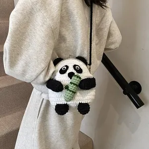 Detail of handmade panda crochet crossbody bag with metal clasp worn by a model