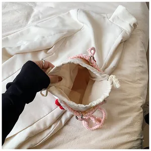 Detail view of the durable cream canvas lining inside this cherry crochet bucket bag