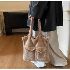 Détail du sac fourre-tout en tricot kaki avec poches boutonnées sur fond intérieur chaud