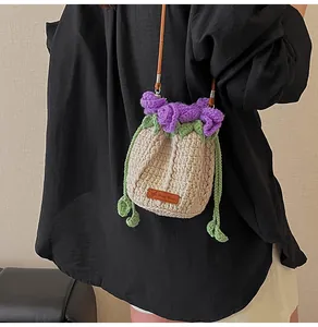 Detail view of handmade crochet rose bucket bag featuring leather strap and hand made tag