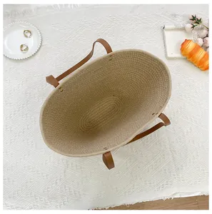 Top view of large straw tote bag with brown leather handles and spacious interior