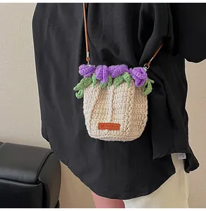 Detail of hand-woven bucket bag with purple crochet flowers and handmade leather tag