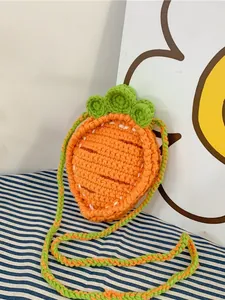 Cute handmade crochet carrot crossbody bag for kids with orange yarn and green leaves