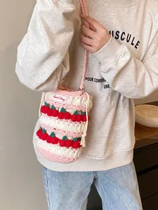 Handmade crochet cherry bucket bag with pink white stripes and 3D cherry accents