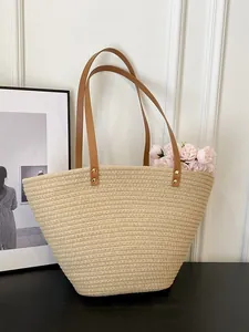 Large beige woven straw tote bag with brown leather handles for summer beach vacations