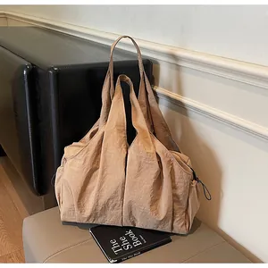 Detail of khaki pleated oversized tote bag with drawstring texture and sturdy handles