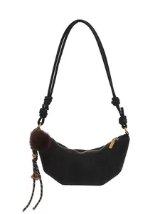 Sac croissant en cuir noir mat avec coutures incurvées et pendentif boule peluche