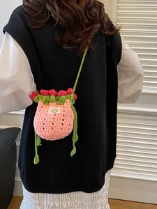 Sac seau fraise crocheté main avec corps en tricot rose et détails de feuilles vertes