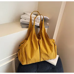 Macro shot of mustard yellow pleated tote bag with drawstring detail and metallic charm