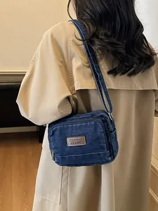 Borsa a tracolla in denim blu scuro lavato con tasche a zip ed etichetta in pelle