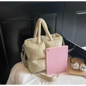 Macro shot of a beige quilted puffy bag with a tablet showing large storage capacity