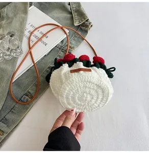 Close-up of hand-crocheted white bucket bag with red roses and leather Hand Made label