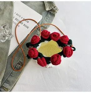 Detail of hand-knitted bucket bag featuring red crochet roses and brown leather strap