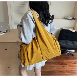 Detail of yellow nylon shoulder bag showing pleated texture and drawstring closure