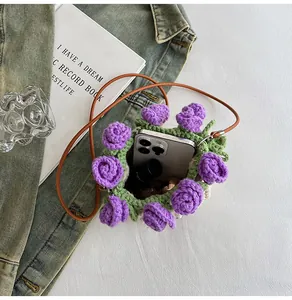 Detail of hand-crocheted bucket bag with purple roses showing phone and cosmetic storage
