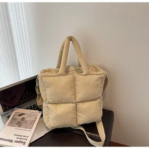 Detailed macro view of quilted puffer tote bag in beige with soft grid pattern texture
