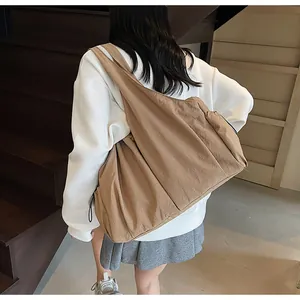 Detail of khaki pleated shoulder bag with wide strap and adjustable drawstring side