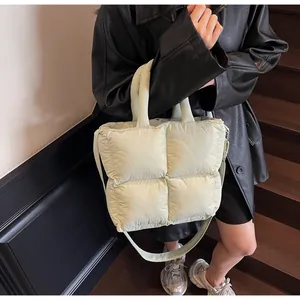 Detail of pistachio green quilted puffer tote bag with soft padded handle and shoulder strap