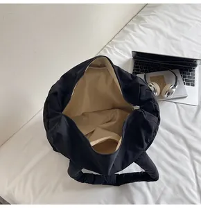 Top view of spacious black quilted tote bag with beige lining and interior zipper detail