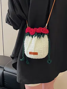 Handmade crochet white bucket bag with red rose accents and brown leather shoulder strap