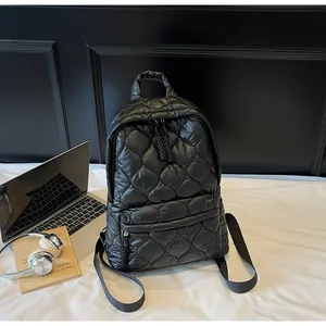 Detail showing the heart-shaped quilted pattern on this black lightweight puffer backpack