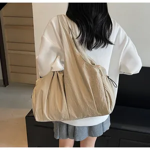 Detail of khaki pleated shoulder bag showing the drawstring ruched fabric texture